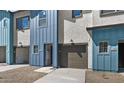 Townhome with gravel landscaping, a front entry door, a garage, and blue exterior accents at 7434 S 75Th Dr, Laveen, AZ 85339
