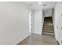 Bright hallway featuring wood-look tile flooring, staircase, and a doorway leading to other rooms at 751 W Flintlock Way, Chandler, AZ 85286