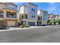Modern townhomes featuring two-story designs with attached garages and landscaped front yards at 751 W Flintlock Way, Chandler, AZ 85286
