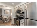 Well-equipped kitchen next to dining area with stainless steel appliances and white shaker cabinets at 7625 E Camelback Rd # A139, Scottsdale, AZ 85251