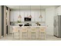 Bright kitchen with white cabinetry, pendant lighting over a kitchen island with seating, and stainless steel appliances at 8323 E Petunia Ave, Mesa, AZ 85212
