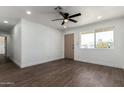 Open-concept living room features hardwood floors, a ceiling fan, and a bright, naturally lit atmosphere at 927 E Greenway Rd, Phoenix, AZ 85042