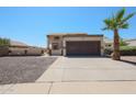 Charming home with a two-car garage, a palm tree, and low-maintenance landscaping in the front yard at 10002 N 66Th Ln, Glendale, AZ 85302