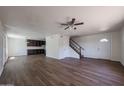 An open-concept living room featuring wood-look flooring, neutral-toned walls, and easy access to the kitchen and staircase at 10002 N 66Th Ln, Glendale, AZ 85302