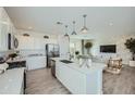 Bright modern kitchen boasts white cabinetry, stainless steel appliances, and island with pendant lighting at 10107 E Ulysses Ave, Mesa, AZ 85212