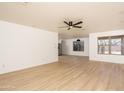 Open concept living room with a large window with backyard views and laminate floors at 12424 N B St, El Mirage, AZ 85335