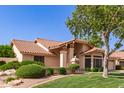 View of the home's exterior featuring desert landscaping, a well-maintained lawn, and an attractive tile roof at 1258 E Granada St, Mesa, AZ 85203