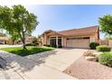 Front exterior showcasing the driveway, tile roof, mature landscaping, and an attached two-car garage at 1258 E Granada St, Mesa, AZ 85203