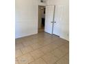 Bright bedroom with neutral walls, tile flooring, and double doors leading to another room at 13208 N 51St Ln, Glendale, AZ 85304