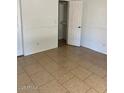 Inviting bedroom featuring tiled floors, light walls, and a closet with a white paneled door at 13208 N 51St Ln, Glendale, AZ 85304