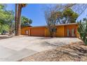 Home featuring a wide driveway leading to a two-car garage and a welcoming entrance at 1417 W Rose Ln, Phoenix, AZ 85013