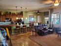 Open concept living room with travertine floors, pendant lights, kitchen island and comfortable seating at 14725 S 182Nd Dr, Goodyear, AZ 85338