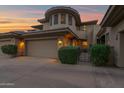 Charming home at twilight with a tan exterior, two-car garage, and manicured landscaping at 15240 N Clubgate Dr # 168, Scottsdale, AZ 85254