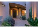 Inviting front porch at twilight with decorative plants and stylish front door at 15240 N Clubgate Dr # 168, Scottsdale, AZ 85254