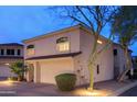 View of the home's front exterior showing the garage, landscaping, and side yard with mature trees at 15550 N Frank Lloyd Wright N Blvd # 1040, Scottsdale, AZ 85260