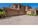 Three car garage with large concrete driveway and desert landscaping at 1808 S Sailors Way, Gilbert, AZ 85295