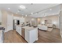 Open-concept kitchen with stainless steel appliances, large island, and seamless flow into the living area at 18916 W Laurel Ln, Surprise, AZ 85388