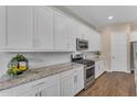 Modern kitchen featuring white cabinets, subway tile backsplash, and stainless steel appliances at 18916 W Laurel Ln, Surprise, AZ 85388