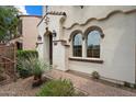 Charming home with a stone-paved walkway leading to an inviting entryway with beautiful architectural detailing at 2004 E Heartwood Ln, Phoenix, AZ 85022