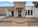 Stone entryway featuring arched windows, exterior lanterns, and a custom iron gate at 21205 E Excelsior Ave, Queen Creek, AZ 85142