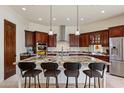 Spacious kitchen island featuring granite countertops, custom cabinetry, and seating at 21205 E Excelsior Ave, Queen Creek, AZ 85142