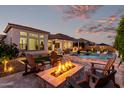 Outdoor entertaining space featuring a pool, built-in grill, and a cozy fire pit with seating at 21449 W Mariposa St, Buckeye, AZ 85396