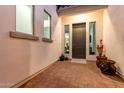 Covered front entry with accent plants and decorative pots create a welcoming arrival at 21449 W Mariposa St, Buckeye, AZ 85396