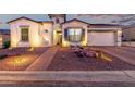 Charming exterior features a well-lit walkway, desert landscaping, and a two-car garage at 21449 W Mariposa St, Buckeye, AZ 85396