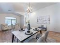 Open-concept dining room with a marble table and stylish chandelier at 23676 W Parkway Dr, Buckeye, AZ 85326