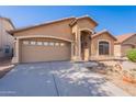 Charming single-level home with a two-car garage and desert landscaping with a well maintained driveway at 23676 W Parkway Dr, Buckeye, AZ 85326
