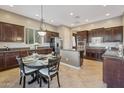 Eat-in kitchen featuring dark wood cabinets, stainless steel appliances, tile floors, and a large breakfast nook at 2472 E Prescott Pl, Chandler, AZ 85249