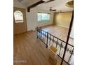Bright living room with hardwood floors, ceiling fans, and large windows showcasing a view at 3144 N 84Th Pl, Scottsdale, AZ 85251