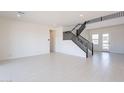 Bright, open living area with sleek tile flooring and a modern staircase at 35234 N Barley St, San Tan Valley, AZ 85144