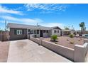 Single story home featuring a concrete driveway, desert landscape and unique concrete fence at 3607 N 79Th Ave, Phoenix, AZ 85033