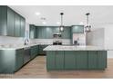 Stunning kitchen with green cabinets, granite counters, stainless appliances and a large center island at 3607 N 79Th Ave, Phoenix, AZ 85033