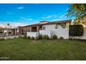 Well-manicured front yard, accented by lush green grass and vibrant bushes enhance the home's curb appeal at 3626 N Mohave Way, Scottsdale, AZ 85251