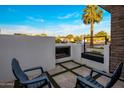 Relaxing outdoor patio features a modern fireplace, stylish seating, and travertine pavers with artificial turf at 3626 N Mohave Way, Scottsdale, AZ 85251