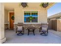 Relaxing front porch featuring neutral decor, hanging flower baskets, and stone accents at 4283 W Nora Dr, San Tan Valley, AZ 85144