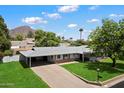 Charming single-story home featuring a carport, well-maintained lawn, and mature tree at 4510 E Calle Tuberia --, Phoenix, AZ 85018