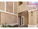 Stucco exterior detailing the front entryway with a white door and desert plants at 529 E Taro Ln, Phoenix, AZ 85024