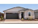 Charming single-story home featuring a dark garage door and decorative stone accents at 5549 S 246Th Ave, Buckeye, AZ 85326