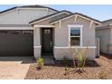Welcoming front entrance with dark wood door, light brick accents, and minimal landscaping at 5549 S 246Th Ave, Buckeye, AZ 85326