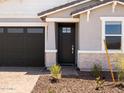 Welcoming front entrance with dark wood door, light brick accents, and minimal landscaping at 5549 S 246Th Ave, Buckeye, AZ 85326