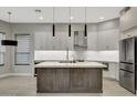 Open kitchen featuring stainless steel appliances, gray cabinetry, and a large center island with bar seating at 7525 E Gainey Ranch Rd # 118, Scottsdale, AZ 85258
