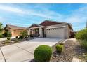Attractive single-story home with manicured landscaping and spacious driveway leading to a two-car garage at 7618 S Lone Pine Pl, Gold Canyon, AZ 85118