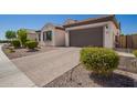 Attractive single-story home with a tile roof, green shutters, paver driveway, and manicured landscaping at 9678 W Patrick Ln, Peoria, AZ 85383