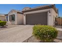Charming single-story home featuring a tile roof, a paver driveway, and a convenient two-car garage at 9678 W Patrick Ln, Peoria, AZ 85383