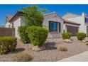 Attractive single-story home with manicured landscaping, rock accents, and lush green bushes at 9678 W Patrick Ln, Peoria, AZ 85383