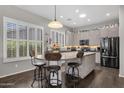 Bright kitchen with large island, pendant lighting, wood flooring, and plantation shutters for natural light at 10359 E Los Lagos Vista Ave, Mesa, AZ 85209