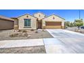 Beautiful single-story house with a two-car garage and mature landscaping on a sunny day at 10548 W Crown King Rd, Tolleson, AZ 85353